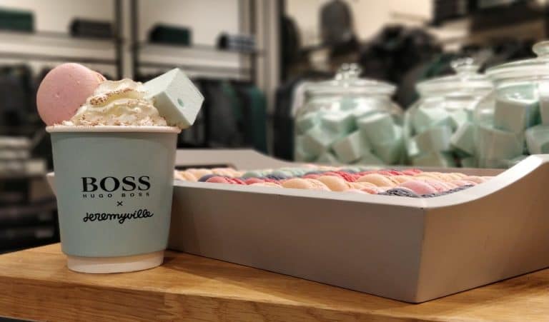 Hugo Boss coffee cup with cream and marshmallows next to a box of raspberry, lemon and blackcurrant macarons and Turkish Delight