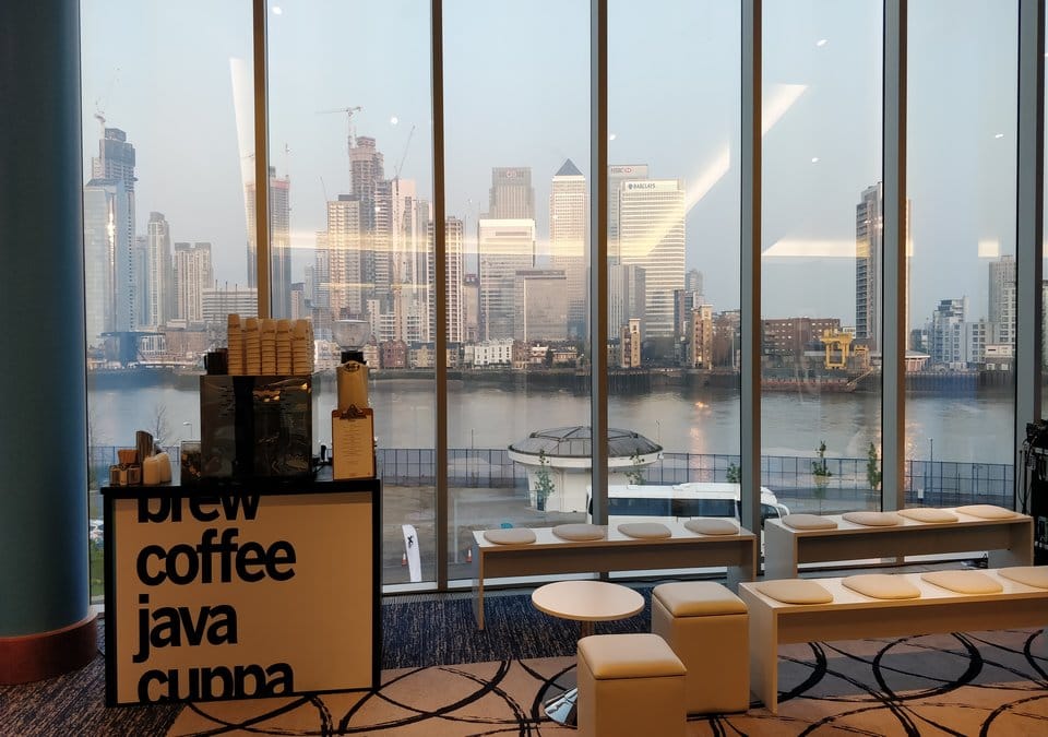 Coffee stall situated next to seating area in front of large window overlooking the city