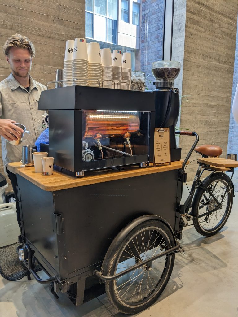 barrista preparing coffee on a Brandded Coffee Bike for Hire
