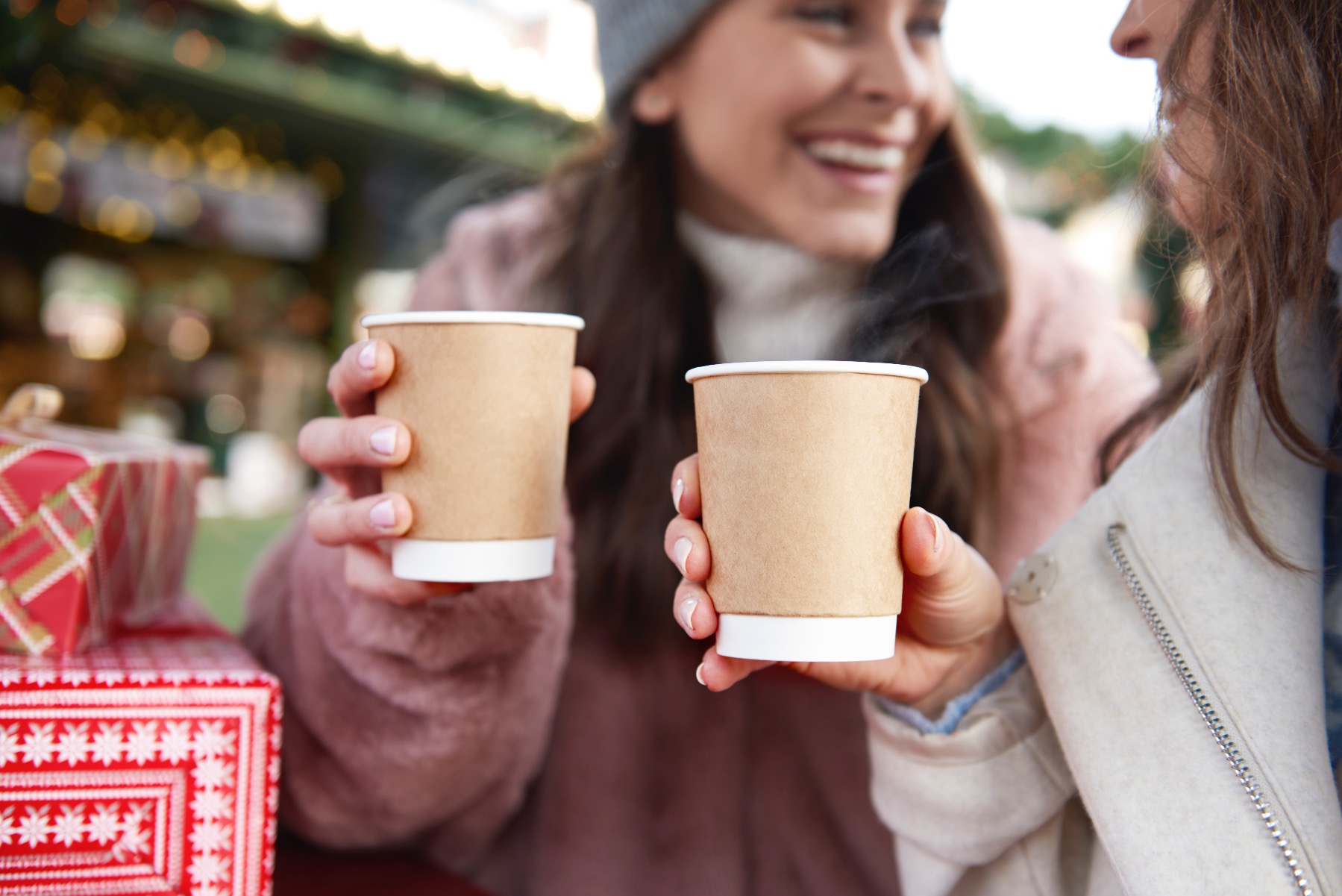 two girls enjoying a warm cup of mulled wine