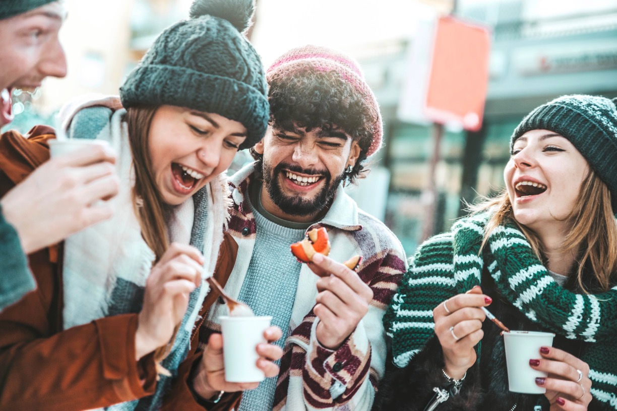 Group laughing while enjoying cup on mulled wine